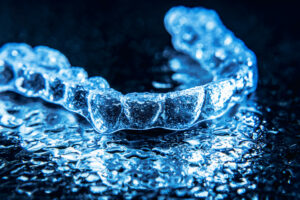 Transparent Aligners, Tooth Retainers Lie On A Mirror With Water Droplets On A Black Background